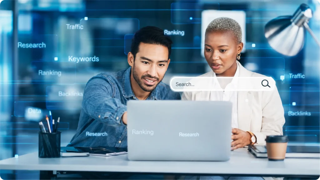 People looking at a laptop on a desk